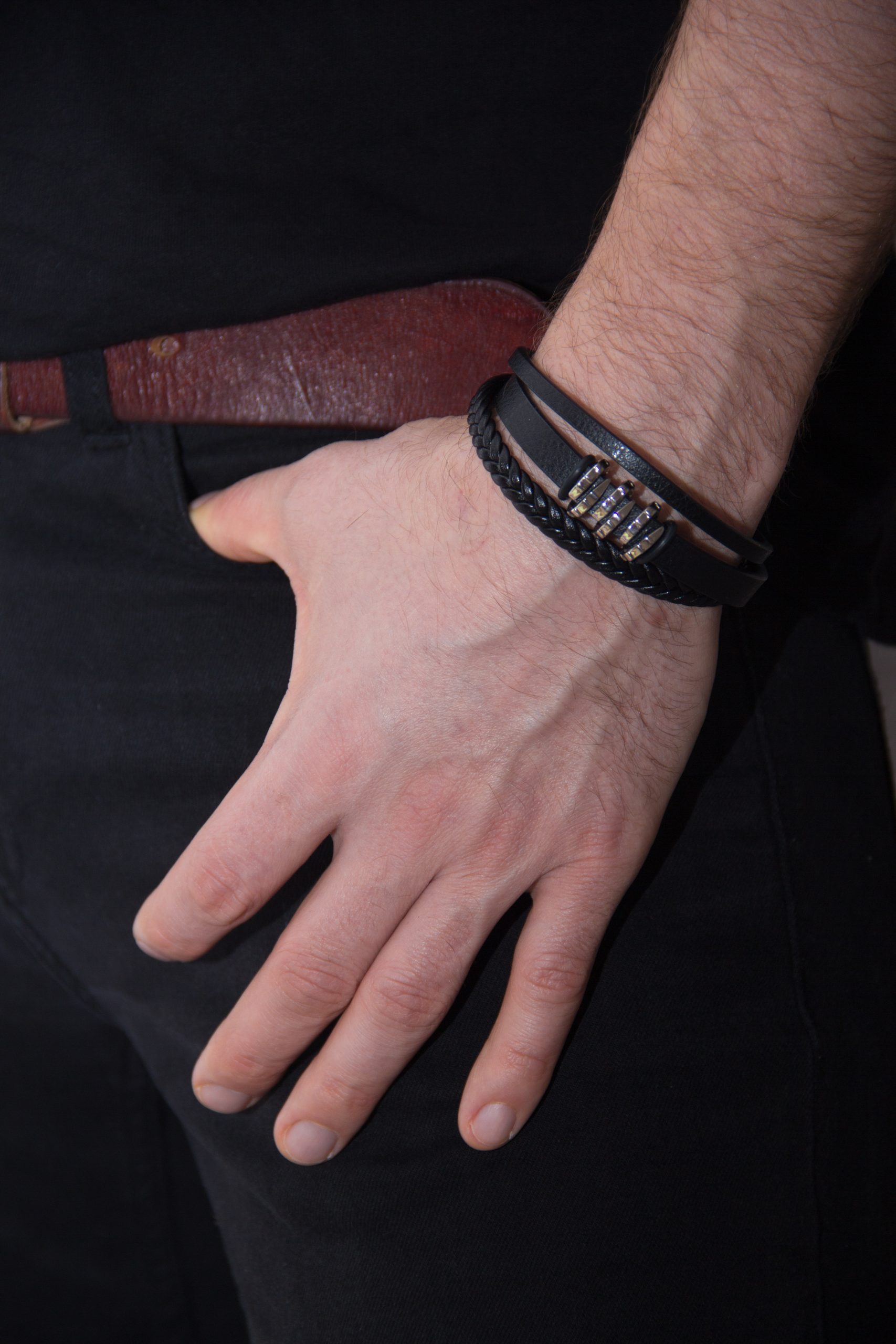 The hand takes out the phone from the pocket, men's accessories, bracelets and leather jacket